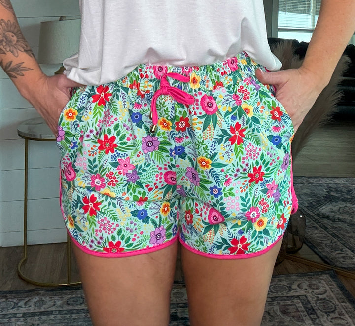 The Wild Blossom Shorts - mid-rise,  tie waist drawstring for adjustability, and side pockets for convenience,  relaxed fit. Flower pattern.