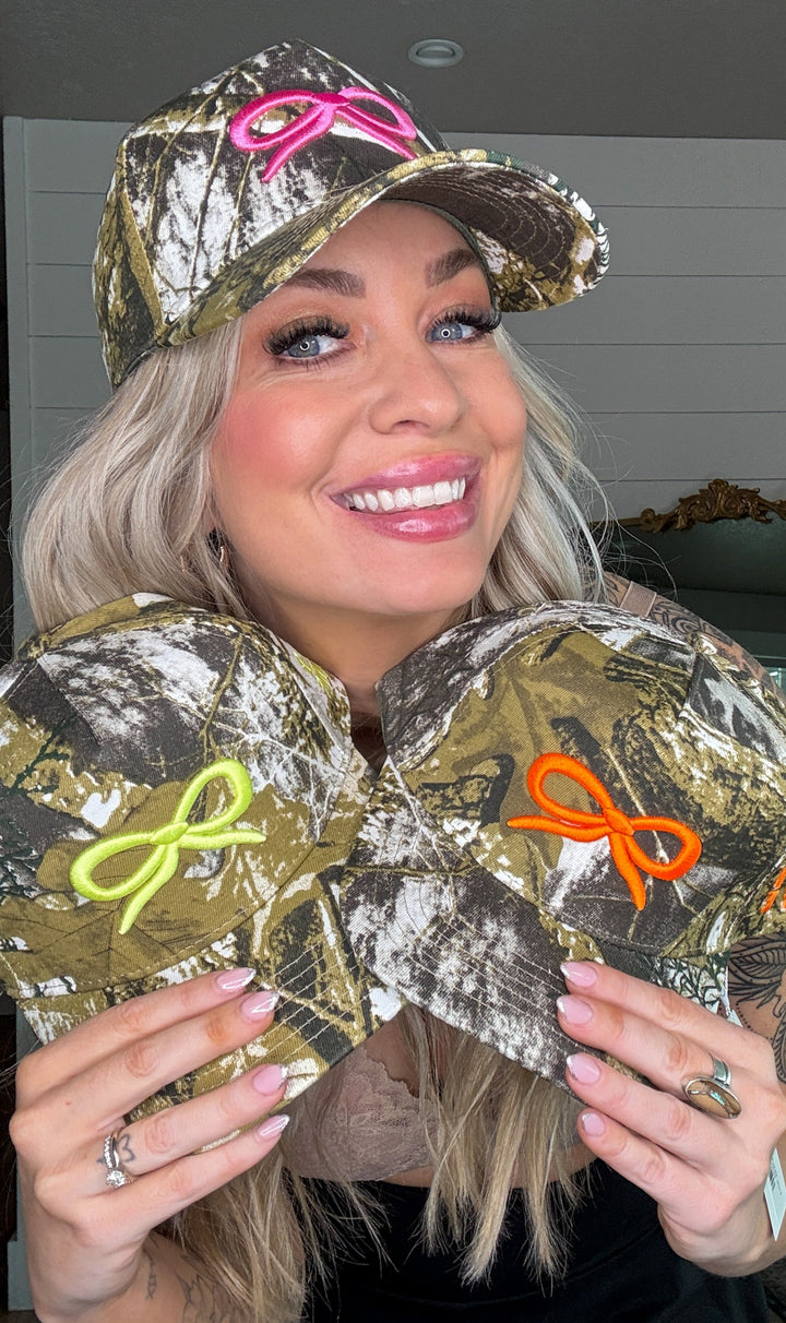 The Backroad Babe Hat - duck camo print, breathable mesh backing, and bold embroidery of a bow.