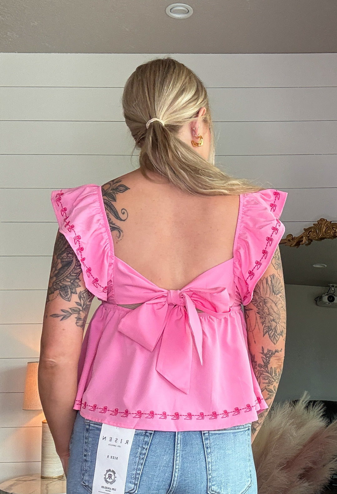 The Brielle Blouse - Pink top with embroidered cowboy boots and bow tie in the back 