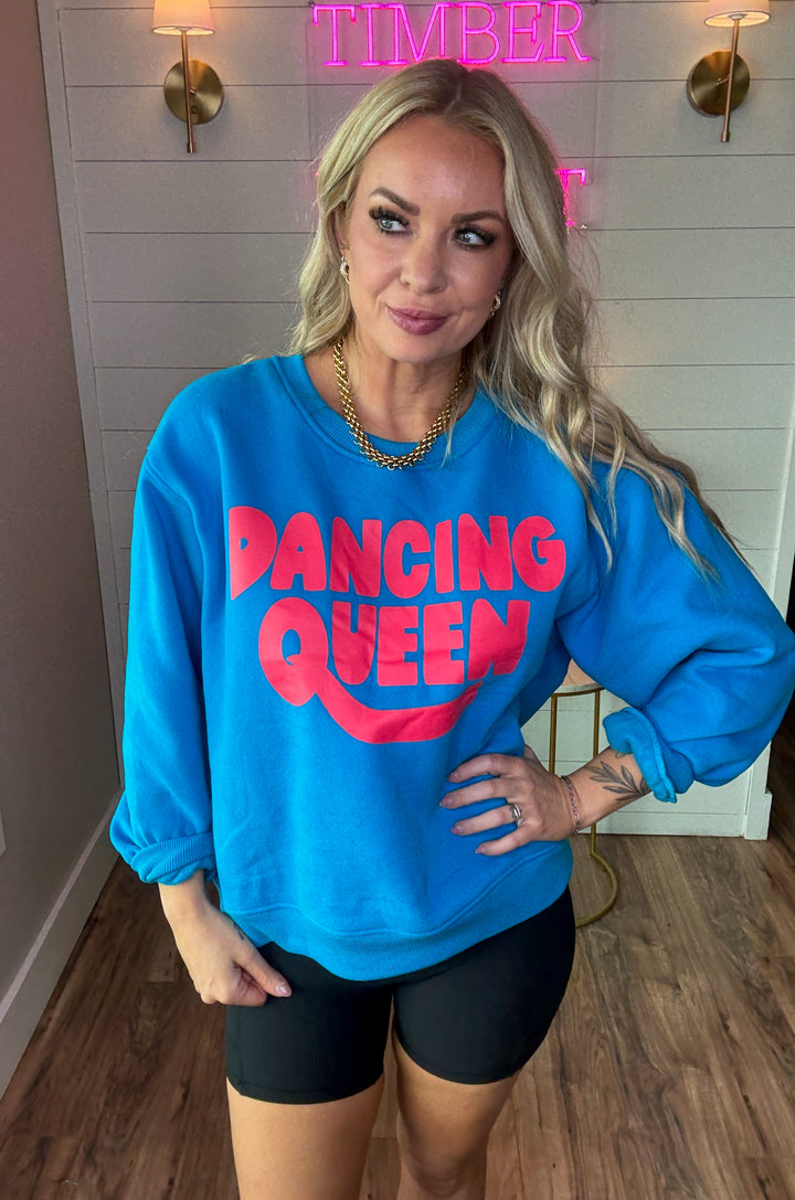 Woman wearing black ribbed biker shorts with side pockets and dancing queen crewneck sweatshirt in bold colors of blue and pink