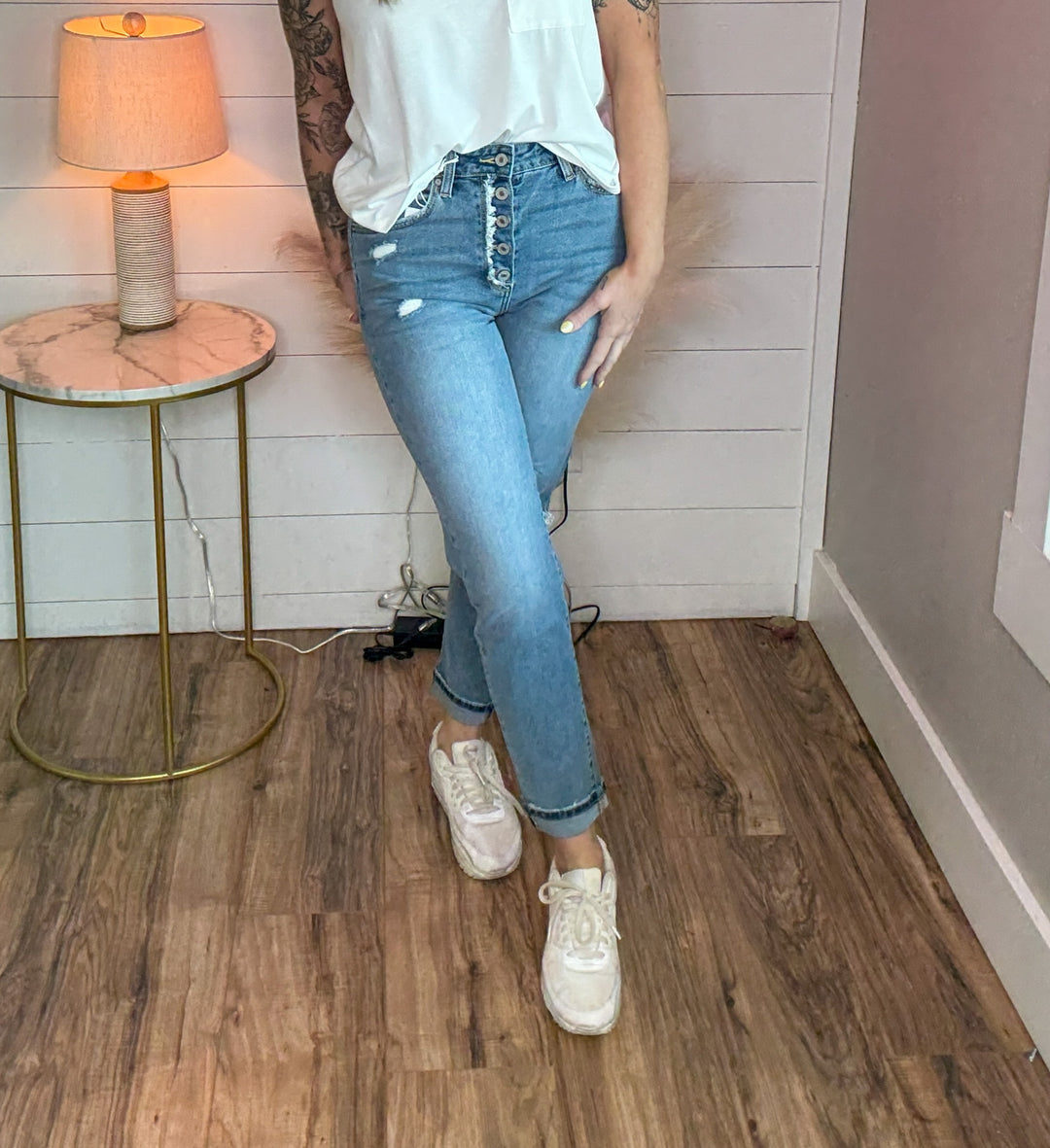 woman wearing KanCan relaxed skinny jean, medium stone wash, and just the right touch of distressing at the knee, button fly with frayed open hem and a white relaxed fit tank top