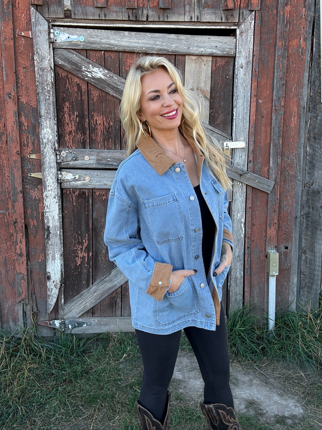 Woman wearing a denim barn jacket in front of a rustic wooden building
