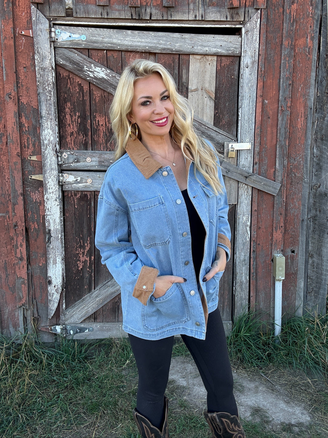 Woman wearing a denim barn jacket in front of a rustic wooden building