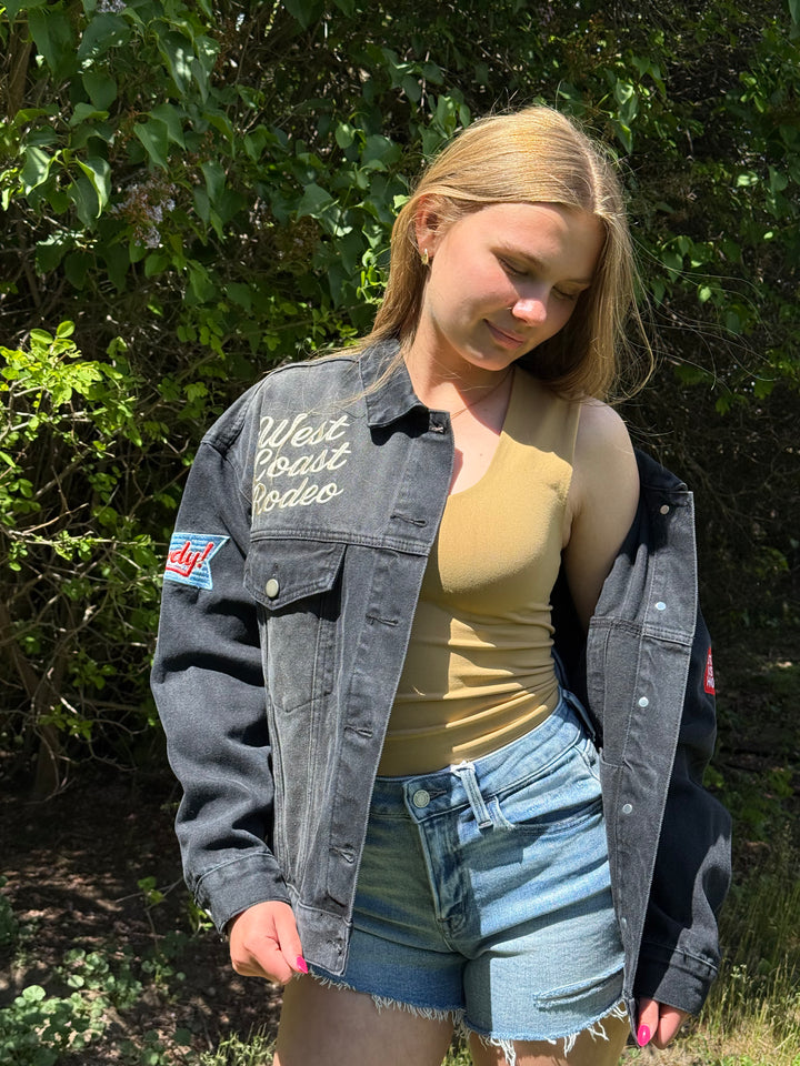 Woman wearing a denim jacket with text &