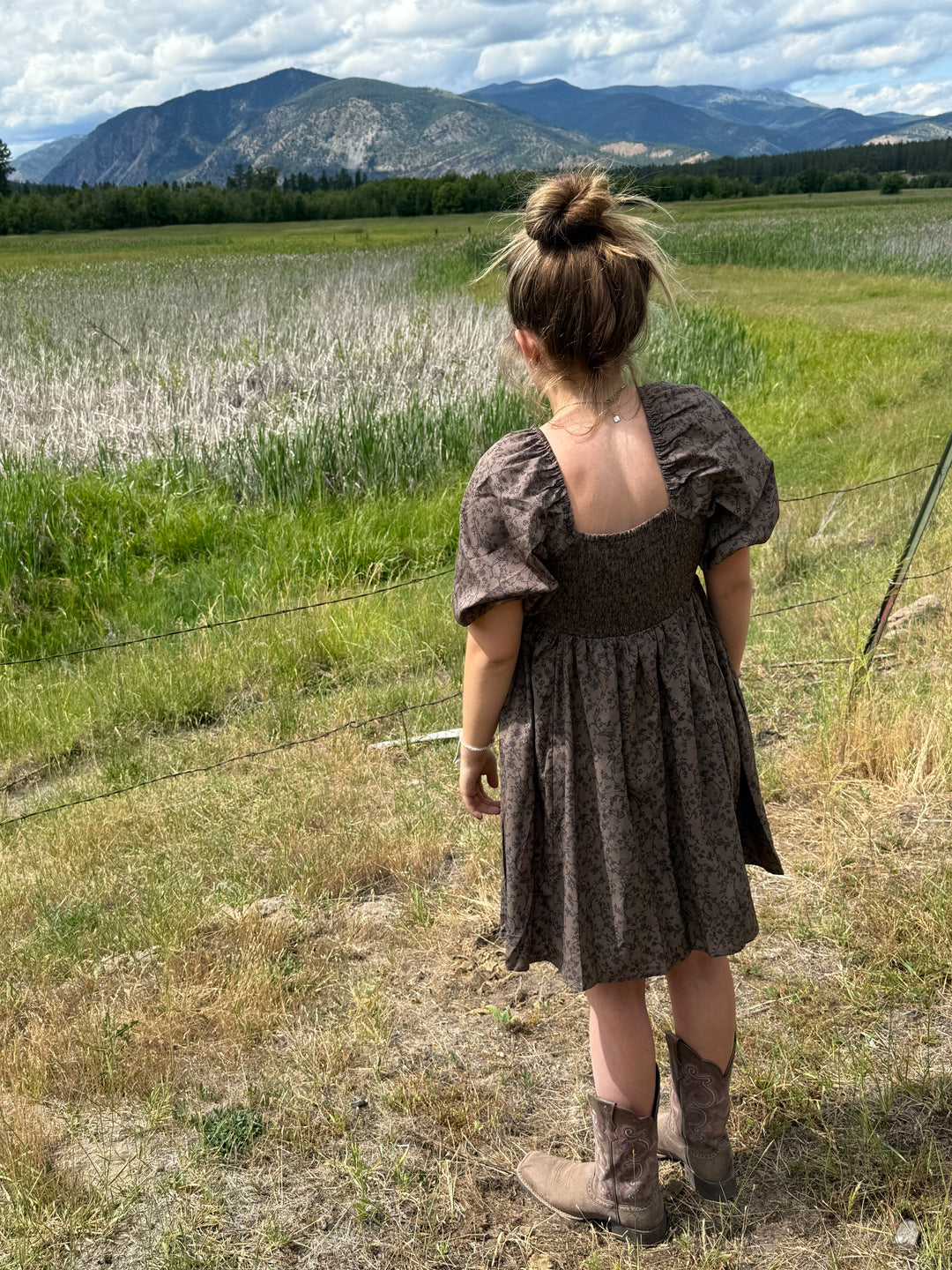 person wearing a Floral dress with puff sleeves and square neckline in chocolate 