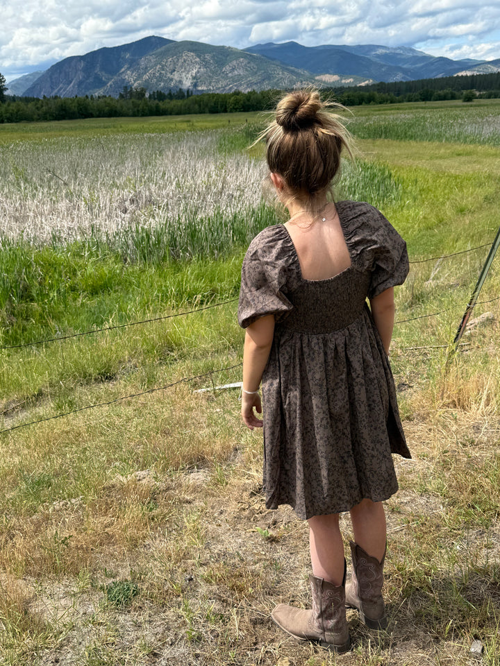 person wearing a Floral dress with puff sleeves and square neckline in chocolate 