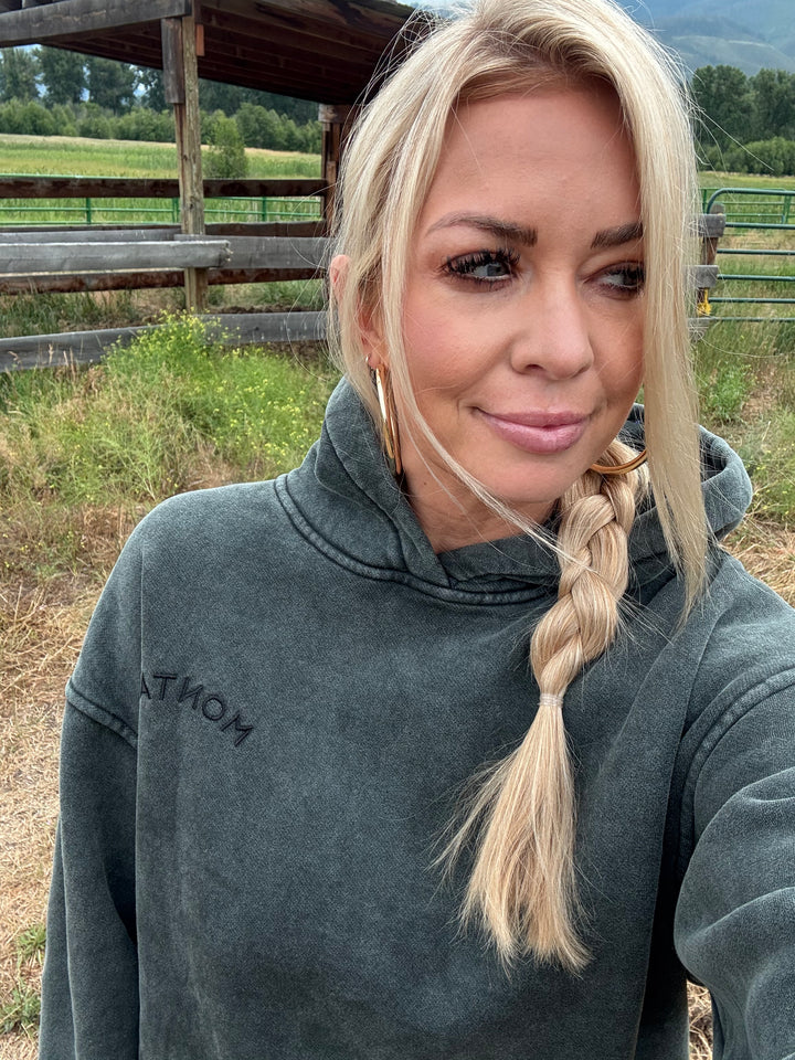 Person with braided hair wearing a gray Montana sweatshirt in an outdoor setting
