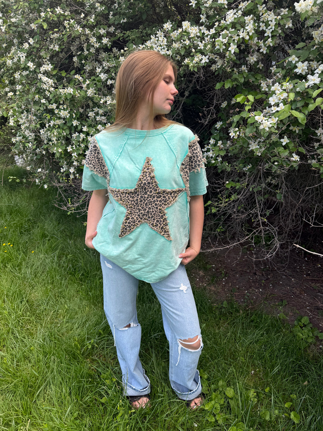 Person wearing a light blue top with a star design outdoors