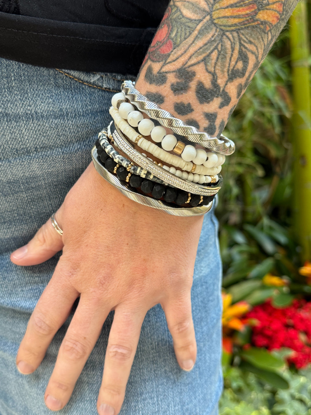 The Wildwood Bracelet Stack -five-piece set features a mix of beads in neutral hues of black, white, and gold