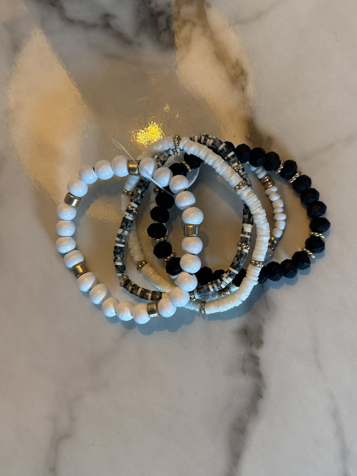 The Wildwood Bracelet Stack -five-piece set features a mix of beads in neutral hues of black, white, and gold