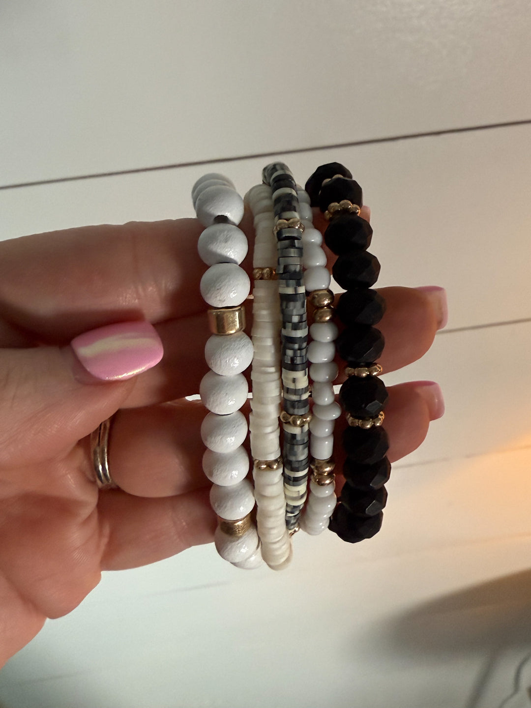 The Wildwood Bracelet Stack -five-piece set features a mix of beads in neutral hues of black, white, and gold