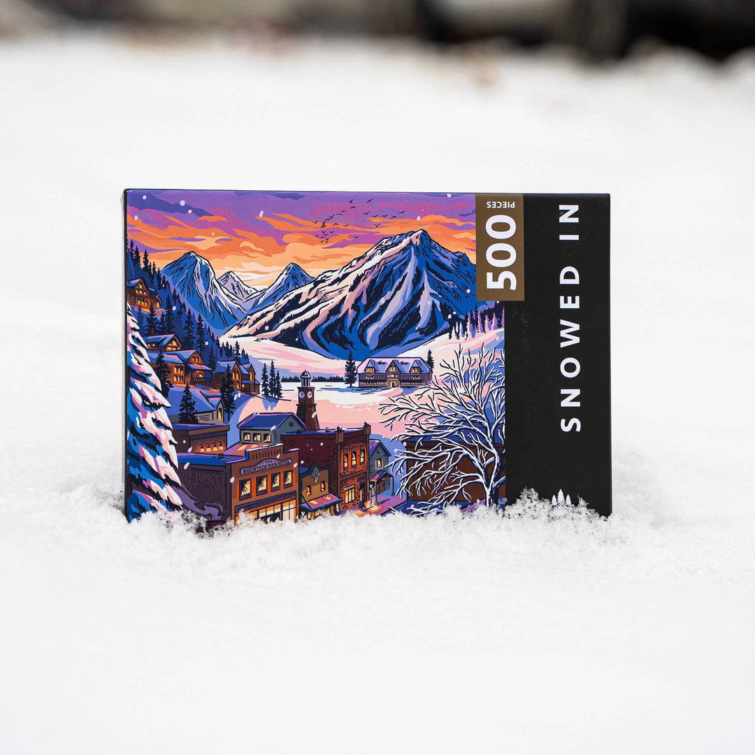Jigsaw puzzle with a mountain and village design on a snowy background