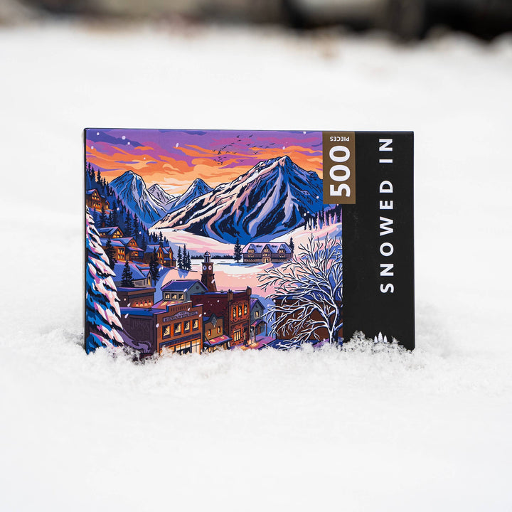 Jigsaw puzzle with a mountain and village design on a snowy background